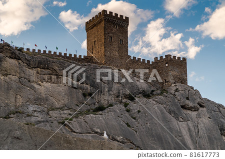 The Republic of Crimea. The city of Sudak. July 20, 2021. View of the walls and towers of the ancient Genoese fortress, located on the fortress hill, from the city embankment. The Republic of Crimea. The city of Sudak. July 20, 2021. View of the walls and towers of the ancient Genoese fortress, located on the fortress hill, from the city embankment. 81617773
