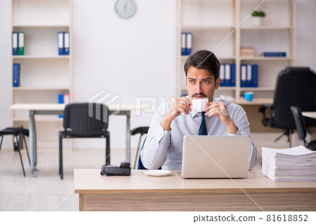 Young male employee drinking coffee during break Young male employee drinking coffee during break 81618852