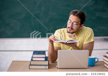 Young male student preparing for exams in the classroom Young male student preparing for exams in the classroom 81619692