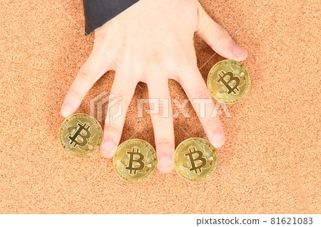 Man's hand holding golden Bitcoin on brown textured cork background. Man's hand holding golden Bitcoin on brown textured cork background. 81621083