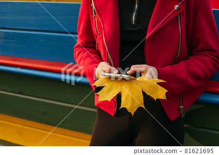Gen z, generation z, Zoomers device addiction, digital detox. Faceless portrait of teen girl holding cell phone and maple leaf in autumn park. Female hands holding smartphone Gen z, generation z, Zoomers device addiction, digital detox. Faceless portrait of teen girl holding cell phone and maple leaf in autumn park. Female hands holding smartphone 81621695