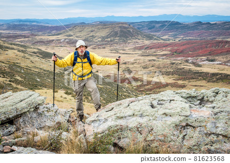 senior male hiker on rocky cliff 81623568