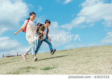 Elementary school students running in the park 81625318