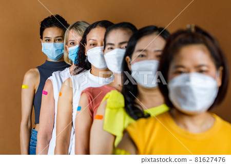 Diversity group of female from multinational ethnic patients wears face mask stand in line by height order look at camera showing colorful plasters on shoulder together after vaccination Diversity group of female from multinational ethnic patients wears face mask stand in line by height order look at camera showing colorful plasters on shoulder together after vaccination 81627476