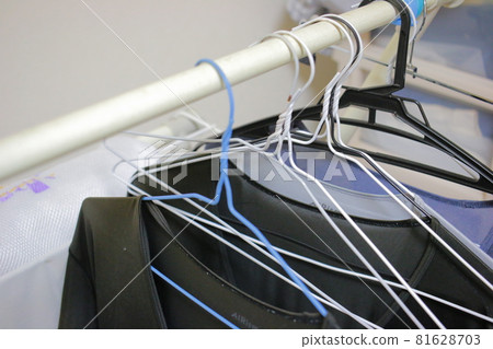 一名男子在室內晾曬的衣物和衣架 81628703