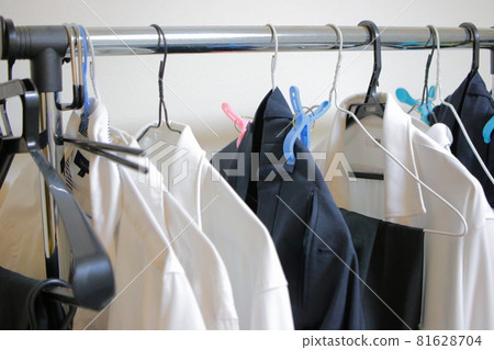 一名男子在室內晾曬的衣物和衣架 81628704