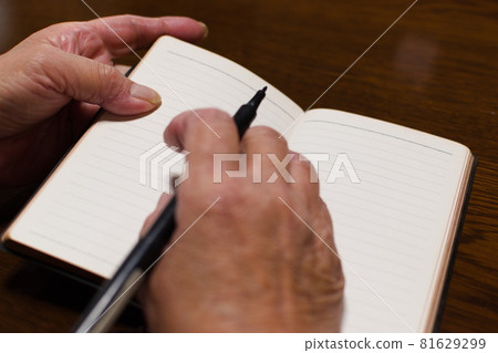 Senior woman's hands taking notes 81629299