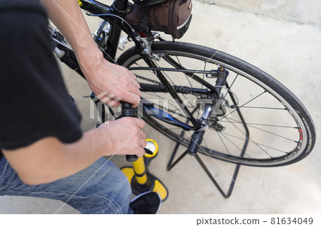A man inflating a road bike 81634049