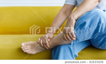 Woman sitting on sofa using hand to hold leg and feeling pain, suffer, hurt and tingling. Concept of Guillain barre syndrome and numb hands disease effect Woman sitting on sofa using hand to hold leg and feeling pain, suffer, hurt and tingling. Concept of Guillain barre syndrome and numb hands disease effect 81635836