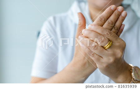 Woman using hand to hold other palm with feeling pain, suffer, hurt and tingling. Concept of Guillain barre syndrome and numb hands disease 81635939