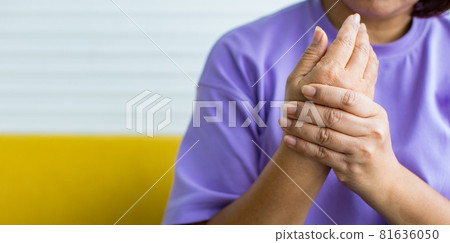 Woman using hand to hold other of her hand with feeling pain, hurt and tingling. Concept of Guillain barre syndrome and numb hands disease 81636050