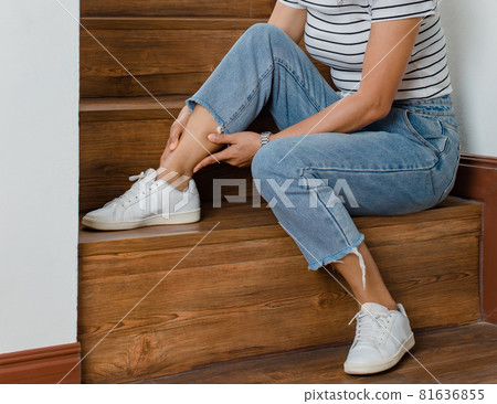 Woman cannot walk climb stair, she stops and use hand hold leg with feeling pain, suffers, hurt and tingling. Concept of Guillain barre syndrome and numb hands disease effect 81636855