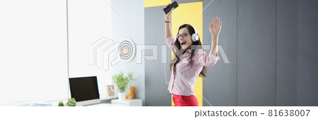 Joyful woman in headphones with smartphone is dancing on couch Joyful woman in headphones with smartphone is dancing on couch 81638007