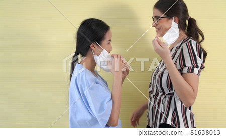 Happy friends take off face mask and hug each other closely together Happy friends take off face mask and hug each other closely together 81638013