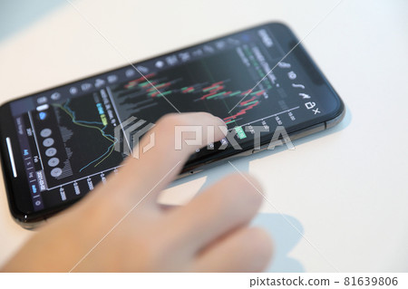 Female hand with smartphone trading stock online in coffee shop , Business concept Female hand with smartphone trading stock online in coffee shop , Business concept 81639806