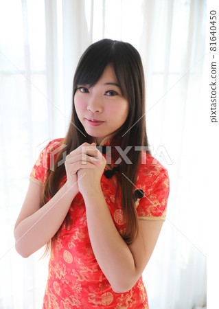 beauty woman wear red cheongsam looking and smile in chinese new year 81640450