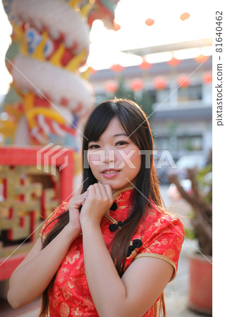 beauty woman wear red cheongsam looking and smile in chinese new year 81640462