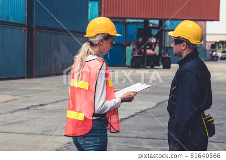 Industrial worker works with co-worker at overseas shipping container yard 81640566