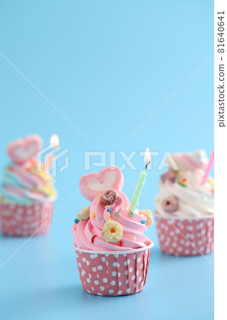 Colorful cupcakes with candle isolated in blue background Colorful cupcakes with candle isolated in blue background 81640641