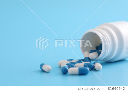 pills capsules with bottle isolated on blue background pills capsules with bottle isolated on blue background 81640642