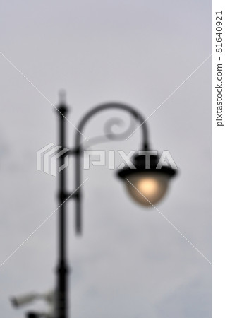 A blurred silhouette of a street lamp, a lantern shining with a voucher 81640921