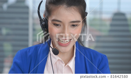 Businesswoman wearing headset working actively in office Businesswoman wearing headset working actively in office 81642580