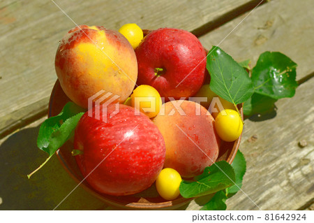 Ripe fruits are in a plate on the table. 81642924