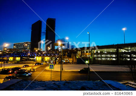 Moscow cityscape at dusk Skyscrapers under construction and snow-covered ground in a clear blue sky 81643065
