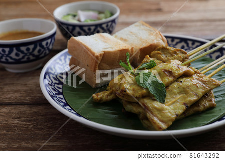 Local Thai food pork satay with oeanut dipping sauce isolated in wood background 81643292