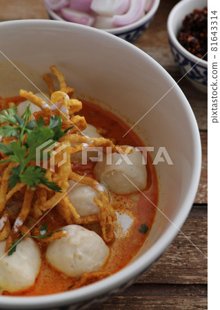 Local northern Thai food Egg noodle curry with meatballs on wood background Local northern Thai food Egg noodle curry with meatballs on wood background 81643314
