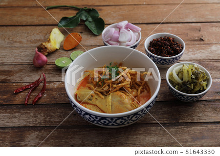 Local northern Thai food Egg noodle curry with chicken on wood background Local northern Thai food Egg noodle curry with chicken on wood background 81643330