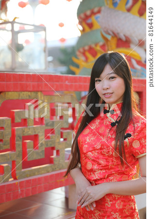 beauty woman wear red cheongsam looking and smile in chinese new year 81644149