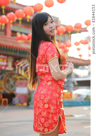 beauty woman wear red cheongsam looking and smile in chinese new year 81644153