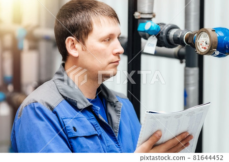 Engineer, worker registers readings of sensors and pressure gauges. Control of water supply and 81644452
