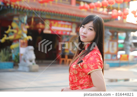 beauty woman wear red cheongsam looking and smile in chinese new year 81644821