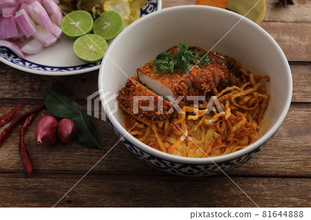 Local northern Thai food Egg noodle curry with fried pork on wood background 81644888