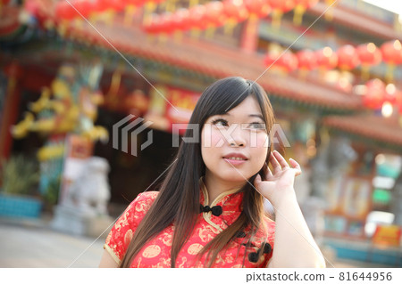 beauty woman wear red cheongsam looking and smile in chinese new year 81644956