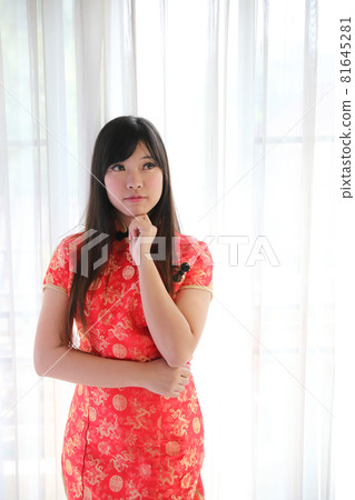 beauty woman wear red cheongsam looking and smile in chinese new year 81645281