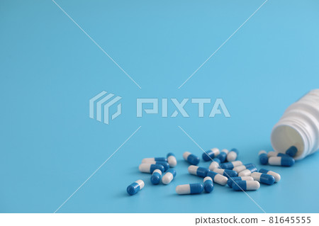 pills capsules with bottle isolated on blue background pills capsules with bottle isolated on blue background 81645555
