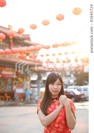beauty woman wear red cheongsam looking and smile in chinese new year 81645724
