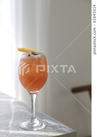 Pink Cocktail glass with ice at gray table Pink Cocktail glass with ice at gray table 81645814