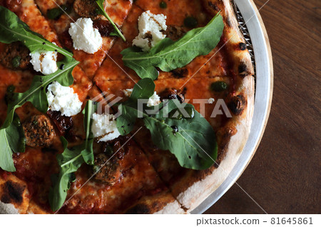 Italian Sausage and rocket salad pizza on wood background 81645861