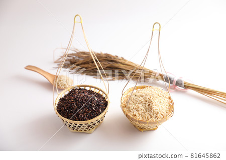 Organic raw brown rice and riceberry rice on wood basket in close up 81645862