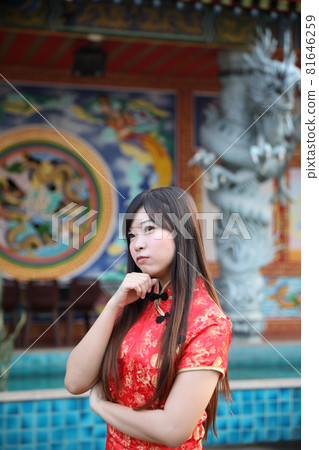 beauty woman wear red cheongsam looking and smile in chinese new year 81646259