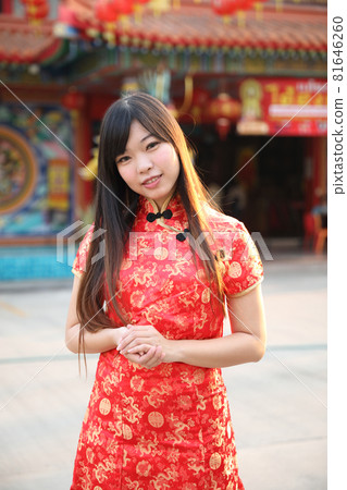 beauty woman wear red cheongsam looking and smile in chinese new year 81646260