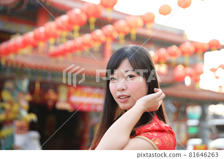 beauty woman wear red cheongsam looking and smile in chinese new year 81646263
