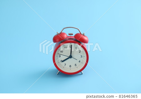 Red retro alarm clock isolated on a blue background 81646365