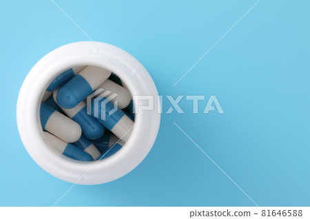 pills capsules with bottle isolated on blue background pills capsules with bottle isolated on blue background 81646588