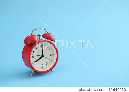 Red retro alarm clock isolated on a blue background 81646610