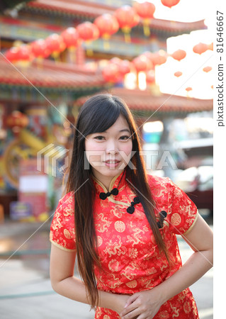 beauty woman wear red cheongsam looking and smile in chinese new year 81646667
